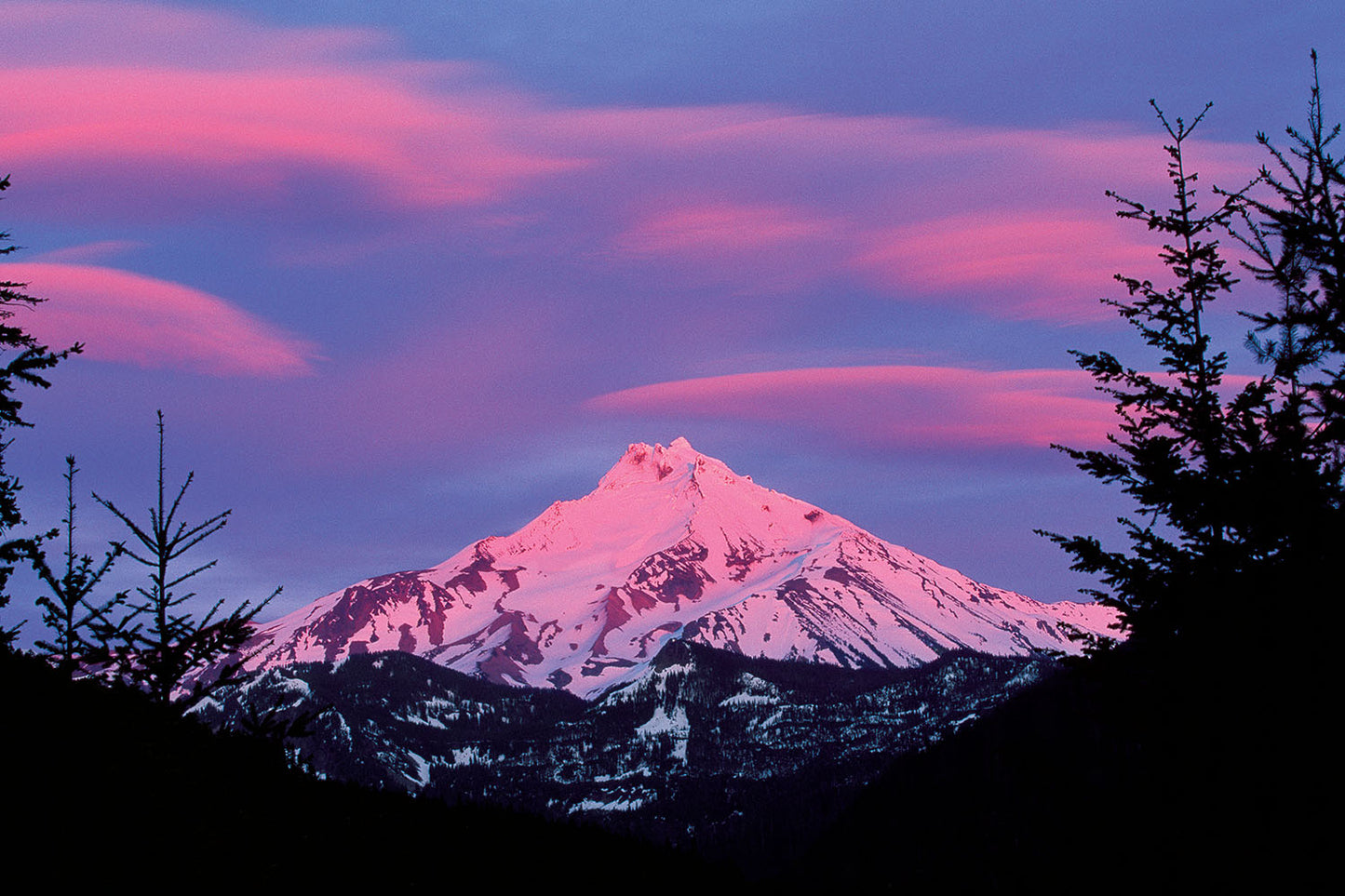 Pink and purple illuminate the sky as the sun sets around Mt. Jefferson, Oregon.