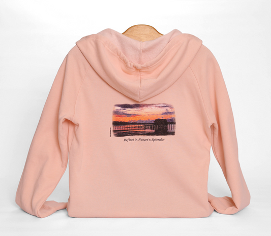 Back view of fleece Oregon Coast hoodie, colored pink, with print of sunset on coastal waters in Garabaldi, Oregon. Caption reading "Reflect in Nature's Splendor" below.
