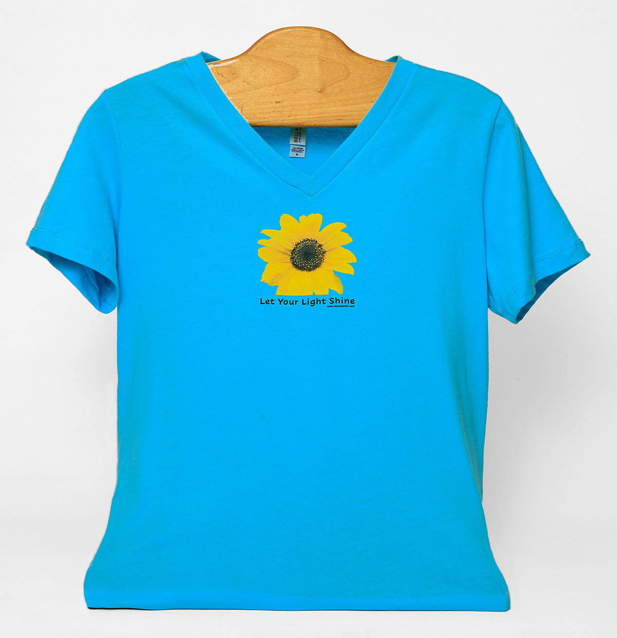 Front view of Sunflower/Let your light shine v-neck T-shirt, colored turquoise. Print features sunflower with caption "Let Your Light Shine".