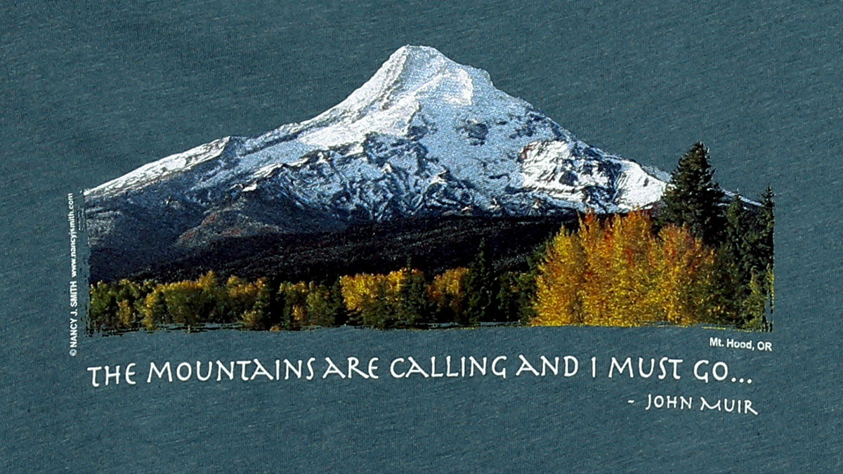 Close detail view of shirt print on color heather slate gray. Features Oregon's Mt Hood and fall trees with caption "The Mountains are Calling and I Must Go..."