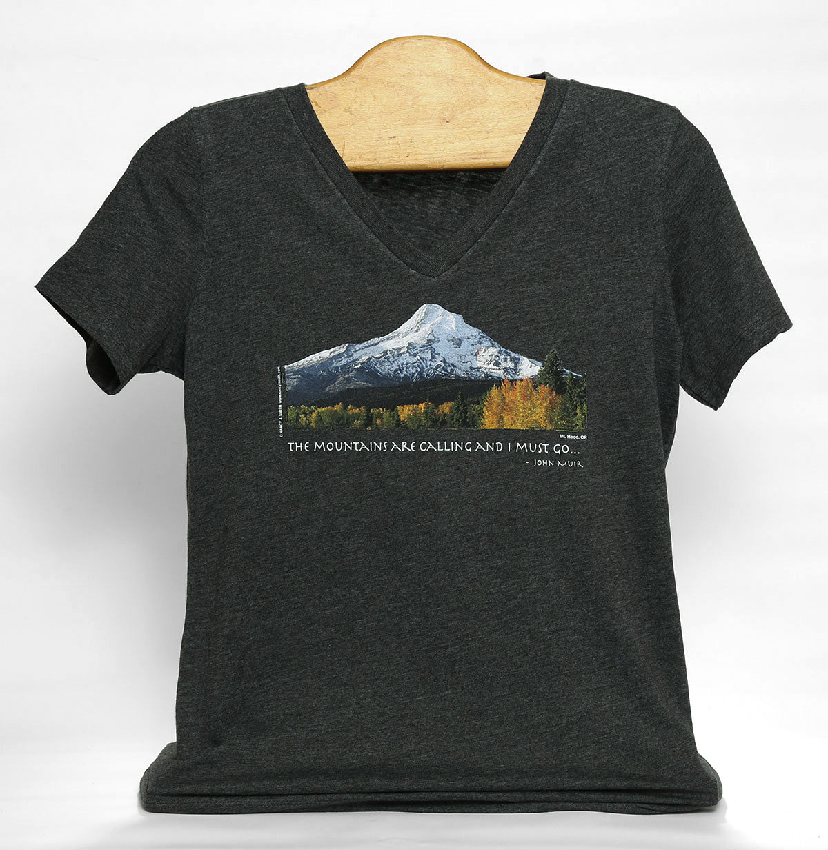 Front view of women's cut Mt. Hood/Fall v-neck t-shirt in color dark grey heather. Features Oregon's Mt Hood and fall trees with caption "The Mountains are Calling and I Must Go..."