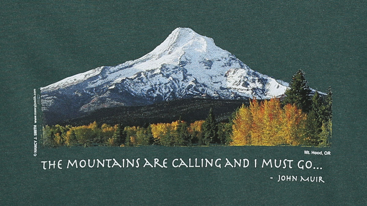 Detail view of shirt print on blue spruce green color. Features Oregon's Mt Hood and fall trees with caption "The Mountains are Calling and I Must Go..."