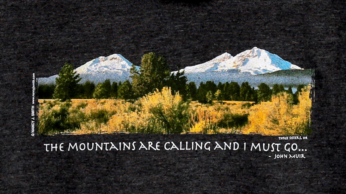 Detail view of hoodie screen print featuring Three Sisters mountains of Oregon and caption "The Mountains are Calling and I Must Go...".