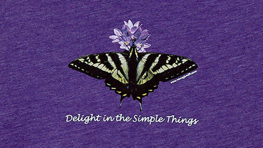 Detail view of shirt screen print. Pale swallowtail butterfly with purple flower. Captioned "Delight in the Simple Things".