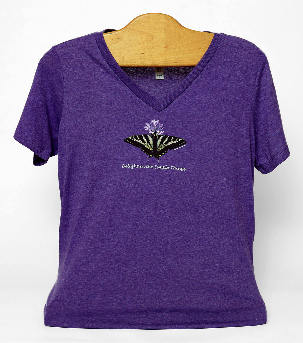 Front view of Butterfly/Delight in the simple things women's T-shirt, colored purple. Print features pale swallowtail butterfly with purple flower. Caption "Delight in the Simple Things".